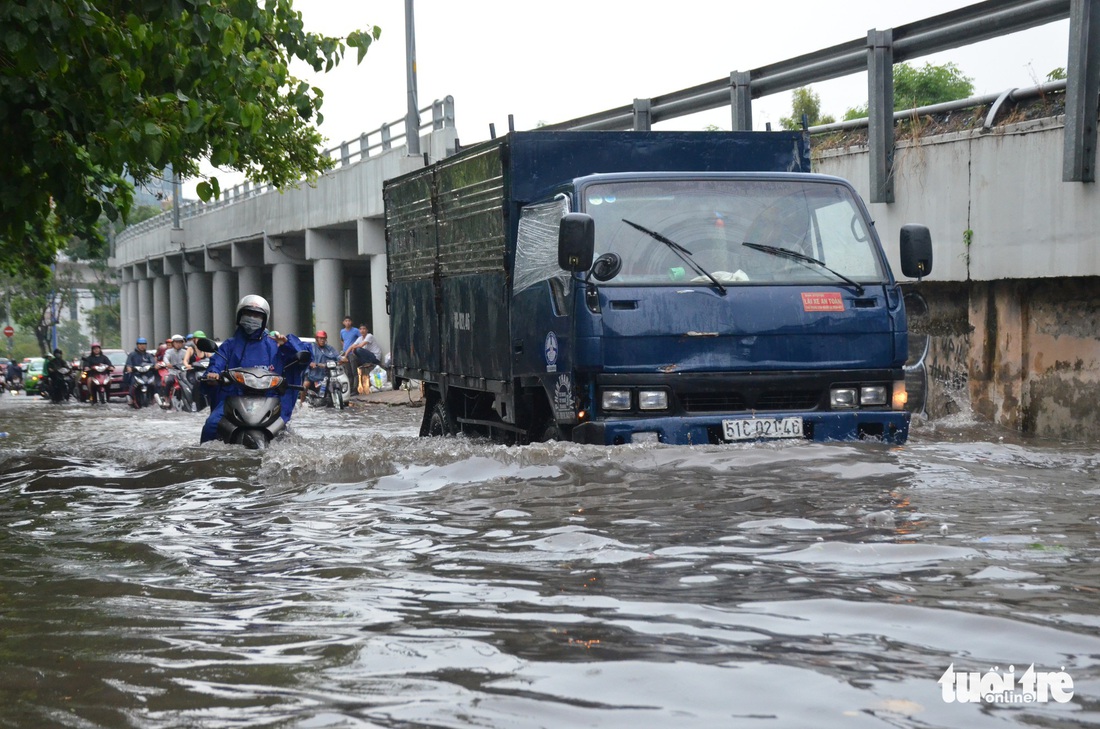 Người dân TP.HCM vật lộn trong mưa đầu mùa gây ngập nửa mét - Ảnh 6.