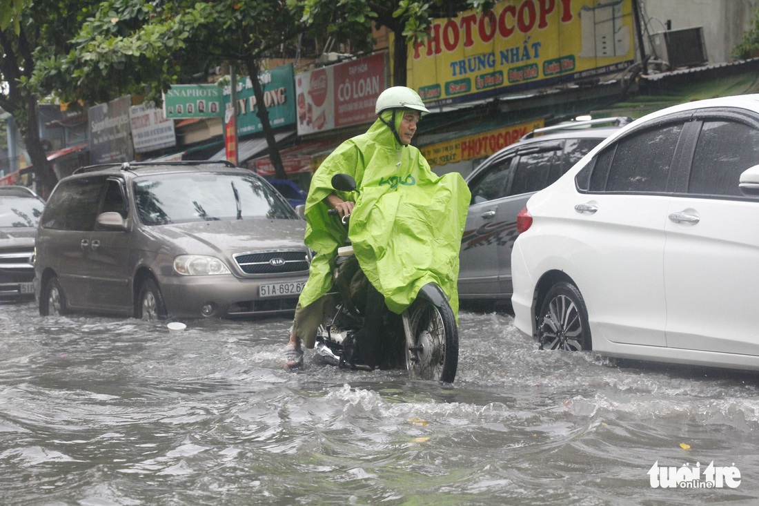 Người dân TP.HCM vật lộn trong mưa đầu mùa gây ngập nửa mét - Ảnh 8.