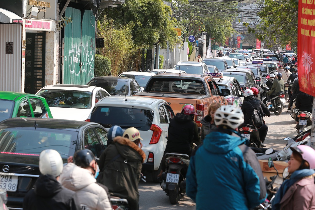 Giữa trưa, dân công sở ùn ùn đi lễ phủ Tây Hồ trong ngày làm đầu tiên sau tết - Ảnh 8.