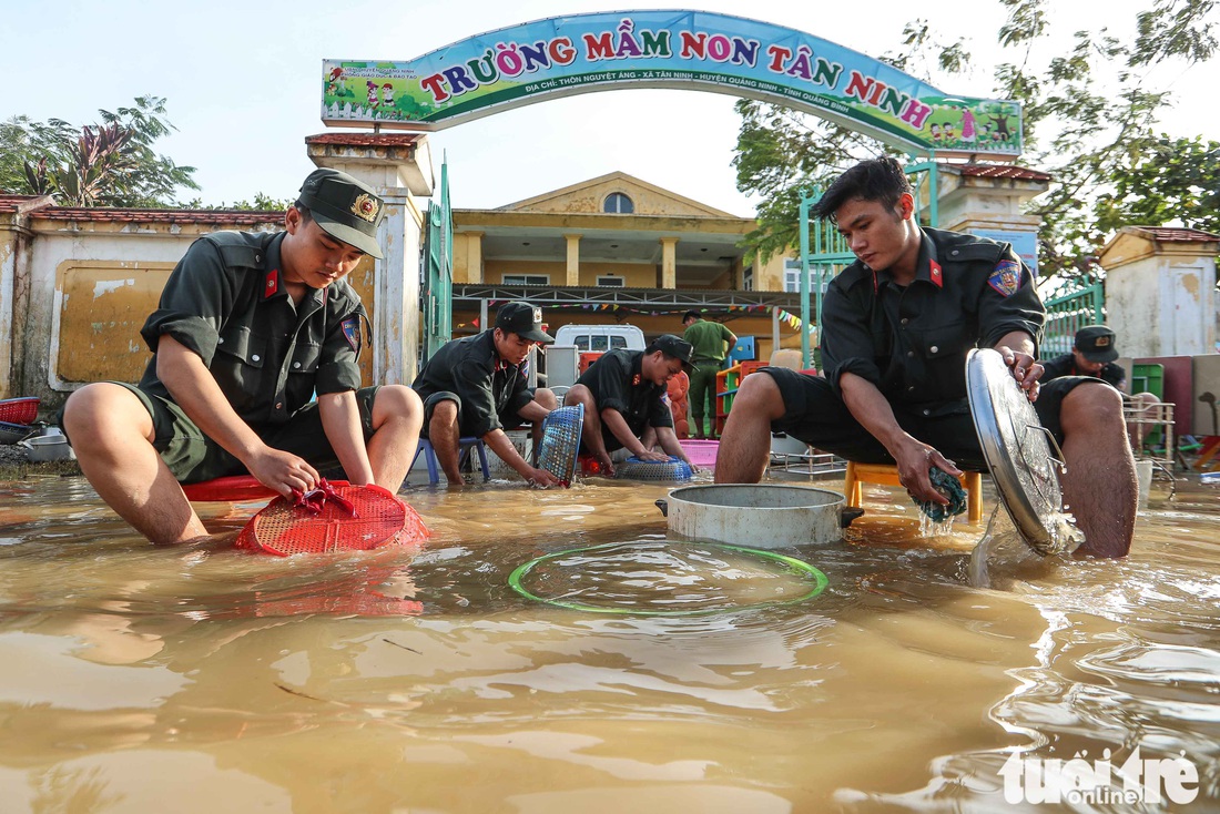 Cả đoàn xe chở cảnh sát cơ động tỏa vào vùng lũ quét dọn, hút nước giúp dân - Ảnh 1.