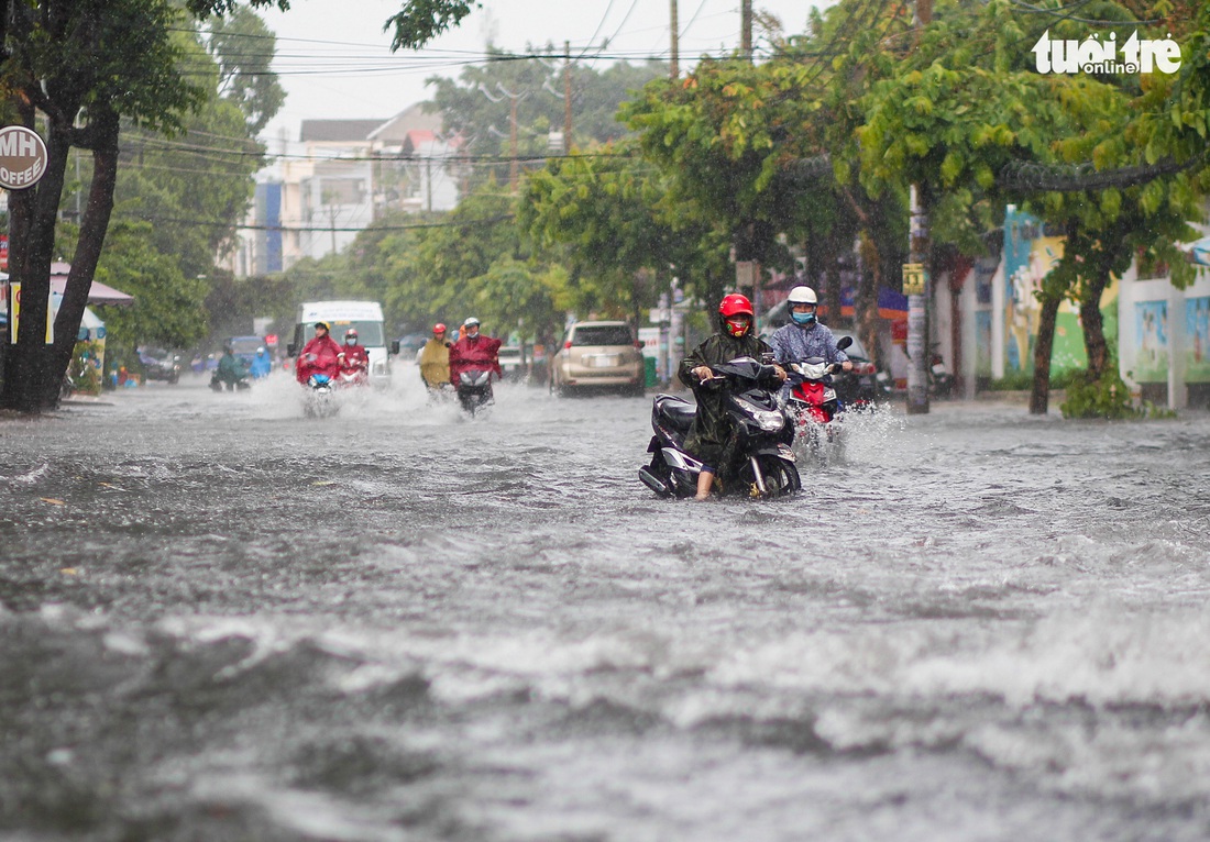 Mưa lớn chiều cuối tuần, nhiều tuyến đường TP.HCM lại mênh mông nước - Ảnh 1.