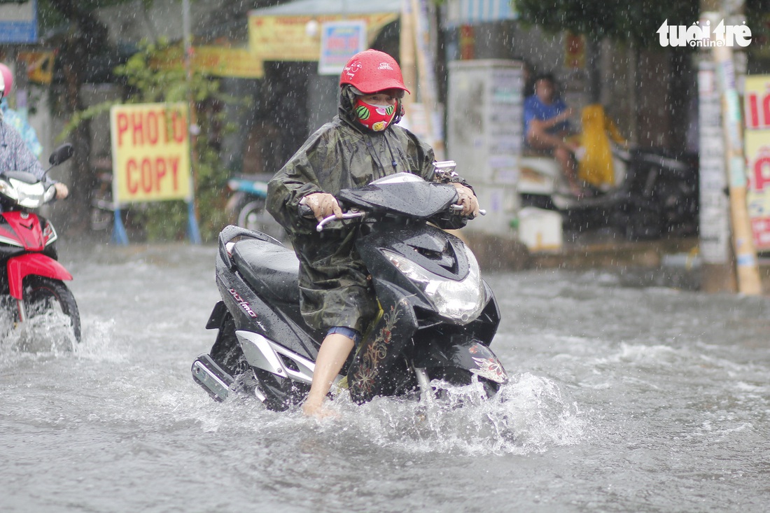 Mưa lớn chiều cuối tuần, nhiều tuyến đường TP.HCM lại mênh mông nước - Ảnh 2.