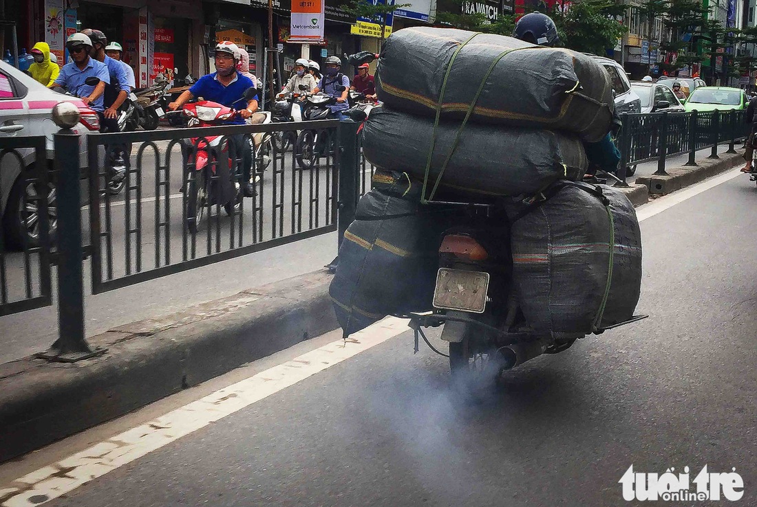Xe máy phế liệu nhả khói đen, chở hàng cồng kềnh trên phố Hà Nội - Ảnh 1. Xe máy phế liệu nhả khói đen, chở hàng cồng kềnh trên phố Hà Nội - Ảnh 1.