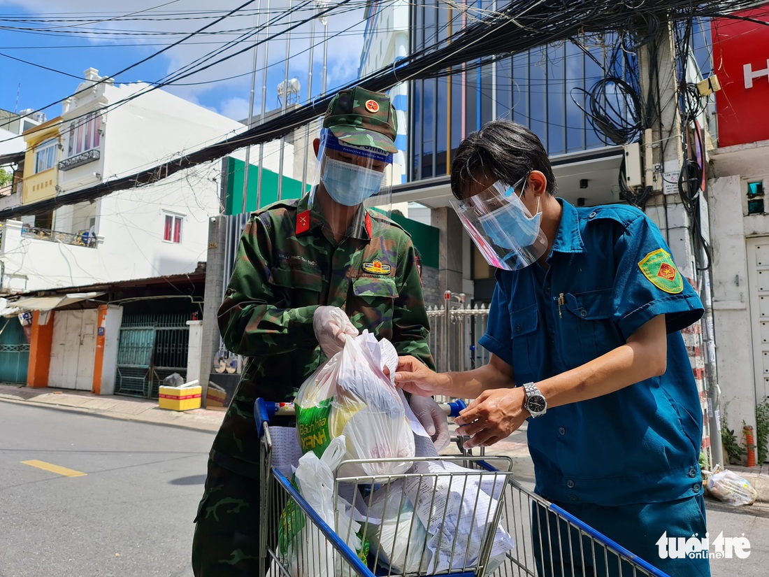 Cán bộ phường, tình nguyện viên cùng đi chợ hộ, mang thực phẩm đến tận nhà dân - Ảnh 15.