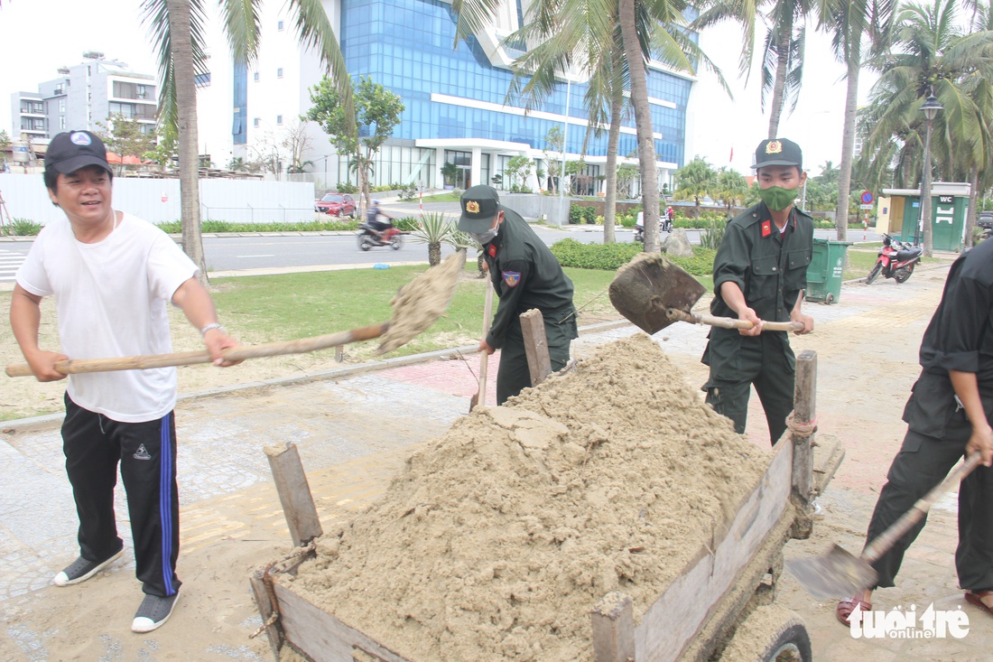 Dân Đà Nẵng kéo ra biển dọn cát lấp, bèo dạt sau bão - Ảnh 4.