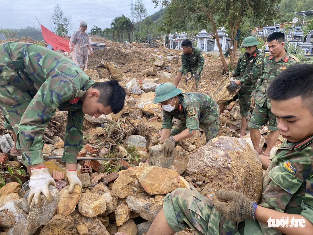 Bới đá, gạn đất tìm lại phần mộ cho dân vùng lũ - Ảnh 1.