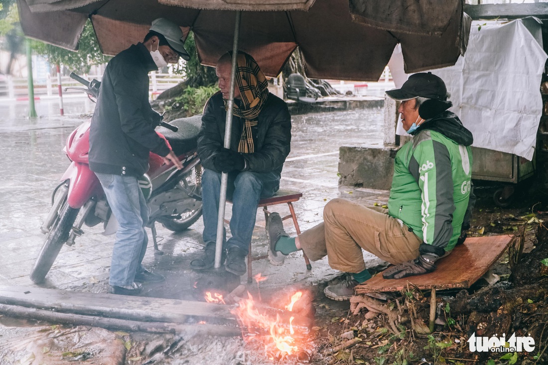 Người lao động ở Hà Nội trùm áo mưa, đốt lửa chống rét để mưu sinh - Ảnh 11.