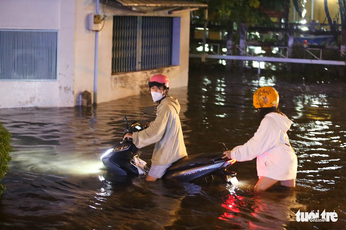 Mưa lớn mù trời, TP.HCM có nơi ngập gần cả mét - Ảnh 2.