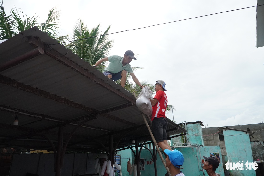 Dân ven biển Quảng Nam xúc cát, cột dây thừng chằng chống nhà cửa, hàng quán tránh bão - Ảnh 2.