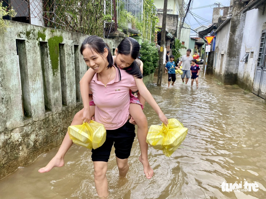 Người dân vùng ngập trở về nhà sau 3 ngày đi lánh nạn - Ảnh: TRƯỜNG TRUNG