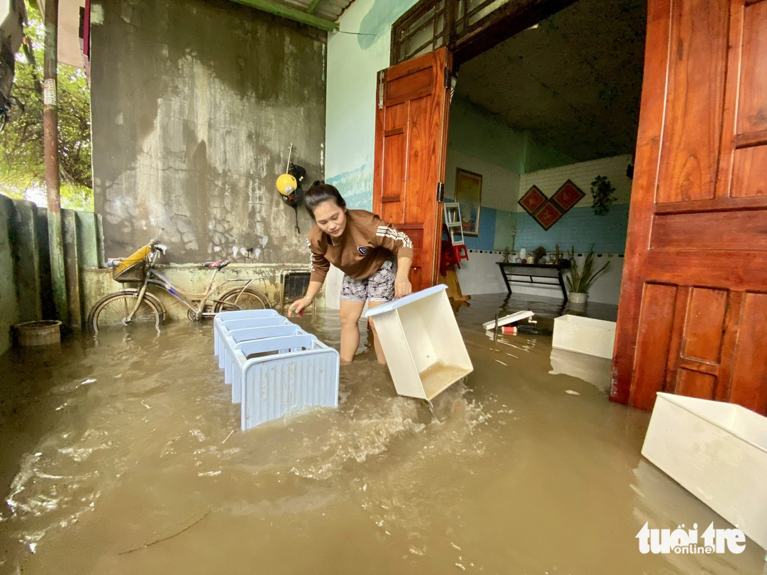 Chị Trần Thị Huyền quay về nhà sau 3 ngày đi lánh nạn nhưng nước trong nhà chưa rút - Ảnh: TRƯỜNG TRUNG