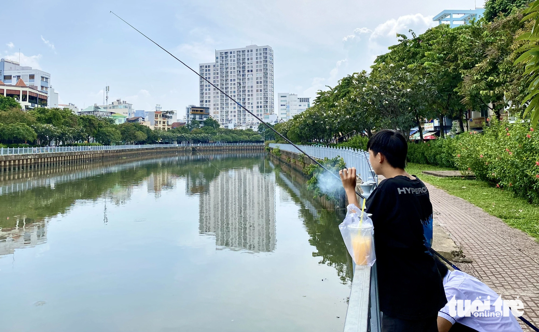 Dù đã đặt nhiều biển cấm nhưng người dân vẫn ngang nhiên đậu xe, câu cá - Ảnh: TIẾN QUỐC