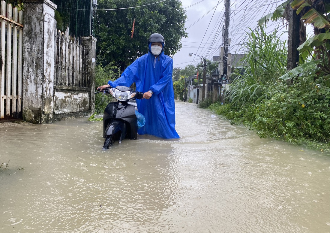 Nước ngập sâu gây khó khăn cho việc đi lại của người dân - Ảnh: LÊ TRUNG