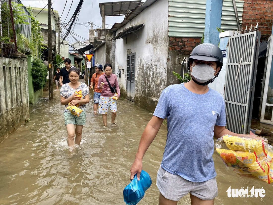 Nhiều bà con vùng ngập trở về nhà với đồ ăn dự phòng được hỗ trợ từ các nhóm tình nguyện viên - Ảnh: TRƯỜNG TRUNG