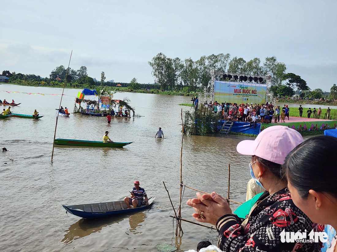 Người dân đứng chật kín khắp tuyến đường để cổ vũ các đội đua xuồng tranh tài - Ảnh: BỬU ĐẤU