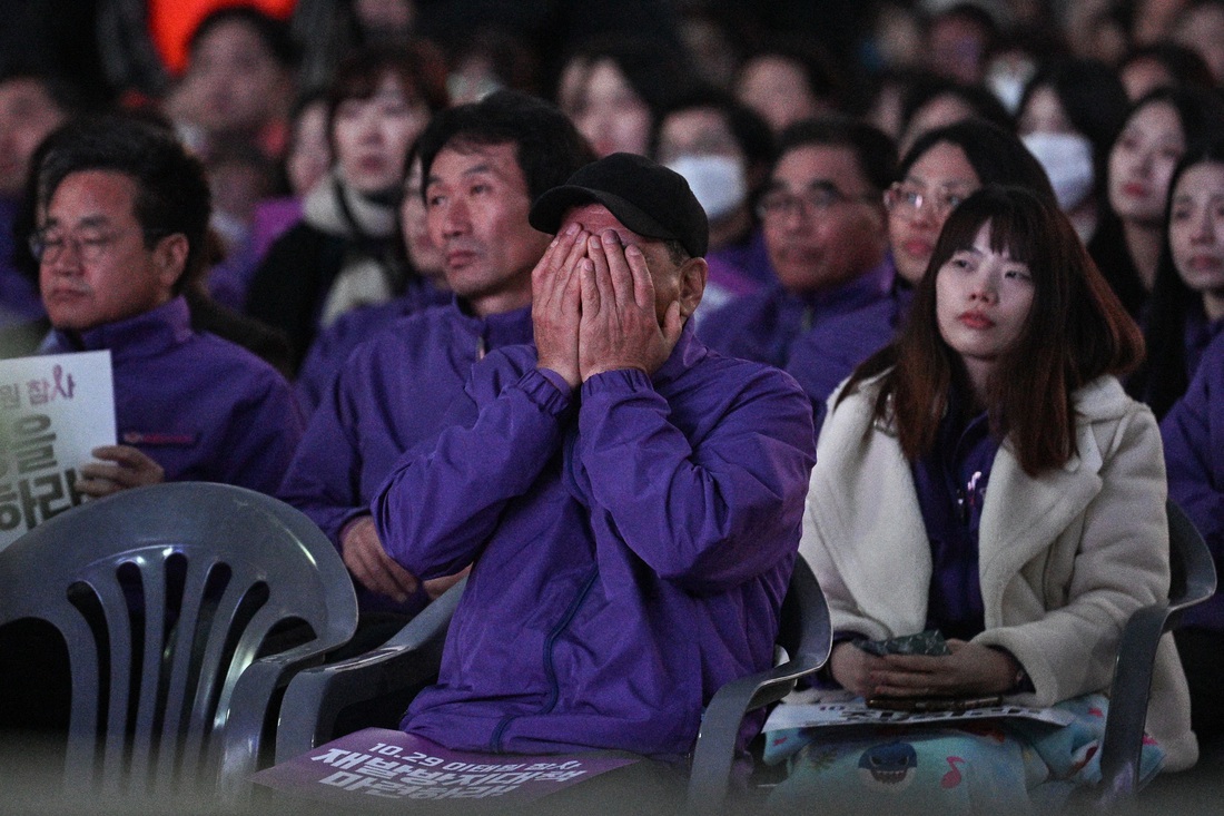 Người thân một nạn nhân ôm mặt khóc khi tham dự hoạt động tưởng niệm - Ảnh: AFP