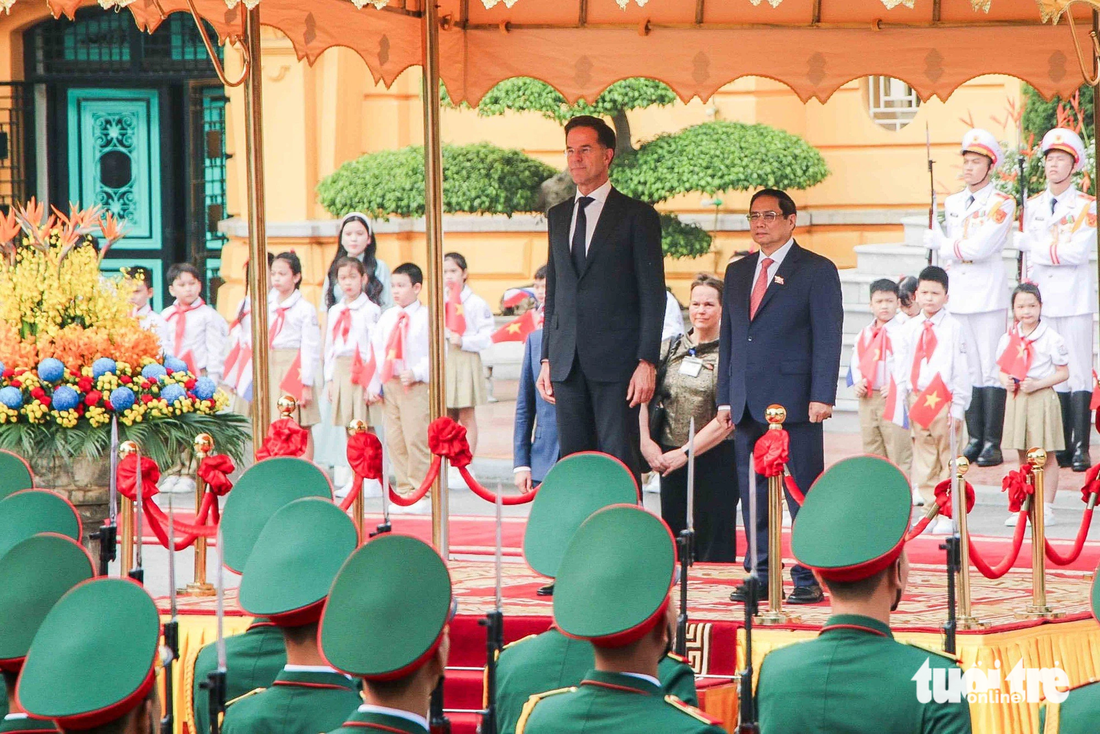 Hai nhà lãnh đạo cùng bước lên bục nghi lễ. Quốc thiều hai nước lần lượt được cử lên - Ảnh: DUY LINH