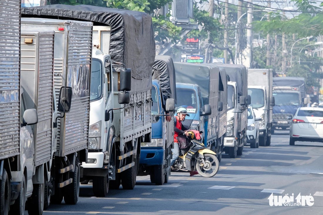 Kẹt xe trên đường Vĩnh Lộc hướng từ huyện Hóc Môn đi Bình Chánh, trưa 21-11. Một người điều khiển xe máy bất chấp nguy hiểm, len lỏi giữa hàng dài xe tải để chạy ngược chiều nhằm thoát khỏi dòng xe đang &quot;đứng im&quot;