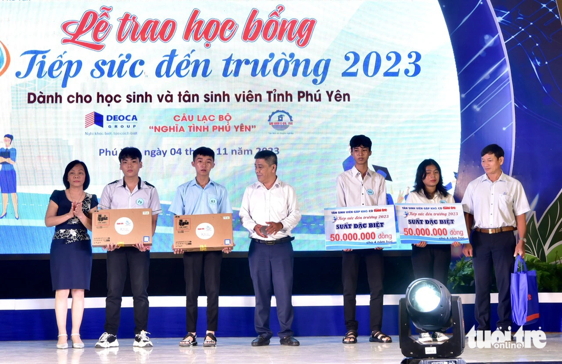 Hai tân sinh viên Đoàn Thái Linh và Lê Ngọc Anh nhận hai suất học bổng đặc biệt trị giá 50 triệu đồng/suất. Và hai tân sinh viên Mai Tấn Thư (Cao đẳng Công thương miền Trung), Võ Đình Nguyên (Đại học Ngoại ngữ và Tin học TP.HCM) nhận laptop do Quỹ khuyến học Vinacam - Công ty cổ phần tập đoàn Vinacam trao tặng - Ảnh: T.T.D.