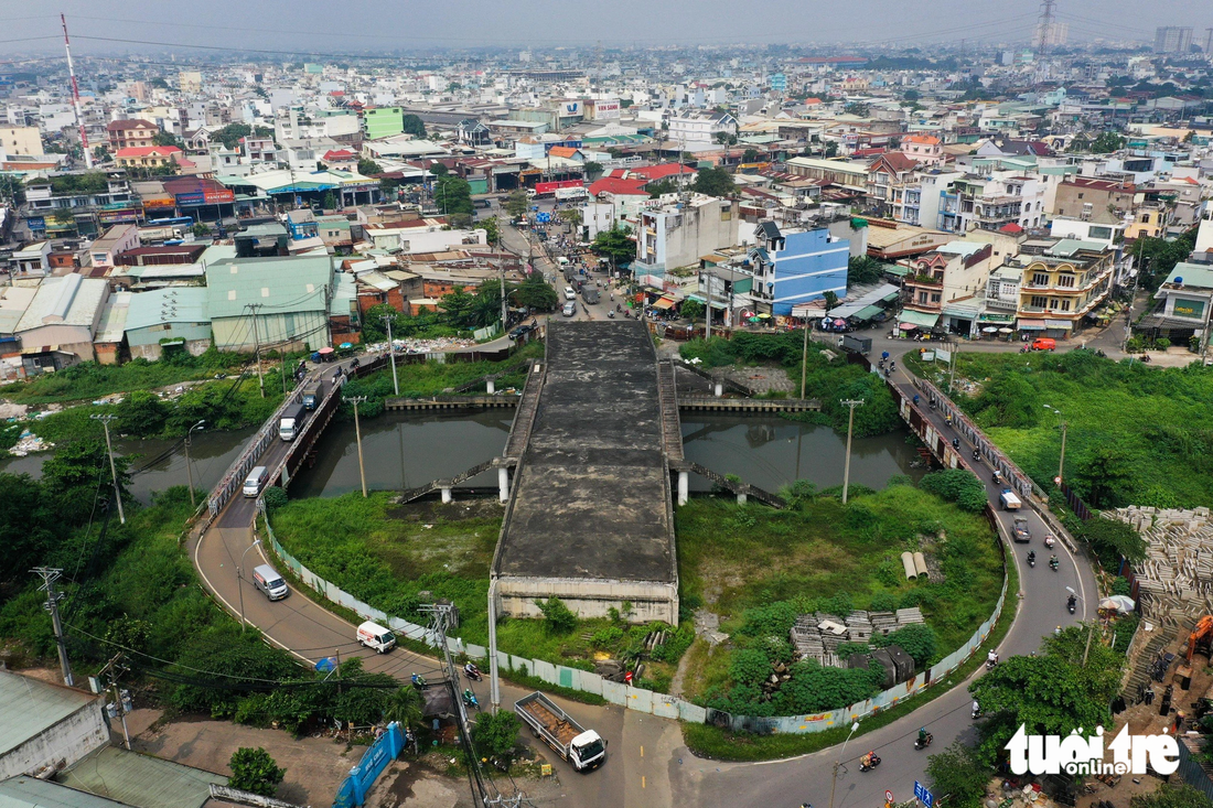 Cầu Tân Kỳ - Tân Quý (phường Bình Hưng Hòa, quận Bình Tân) đã hoàn thành phần giữa cầu bắc qua kênh Tham Lương, hai bên là cầu tạm bằng sắt để người dân đi lại - Ảnh: PHƯƠNG NHI