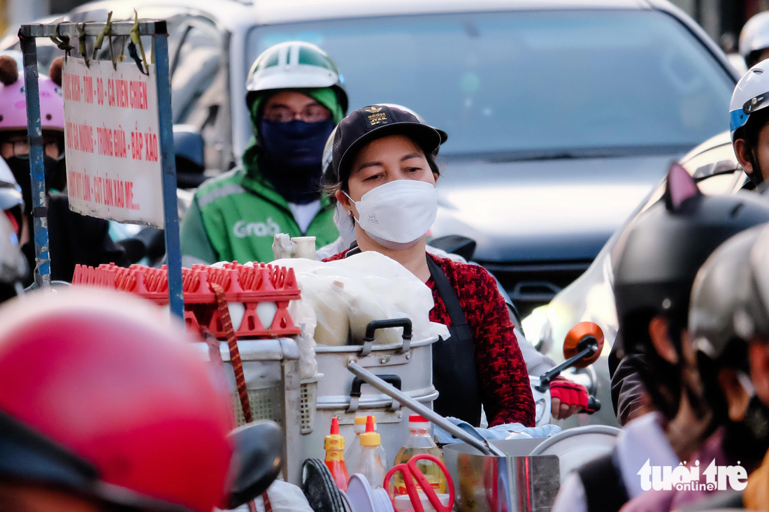 Một phụ nữ đẩy xe hàng rong mệt mỏi vì đã &quot;đứng im&quot; giữa đường Cộng Hòa, đoạn giao với đường Bình Giã được 15 phút