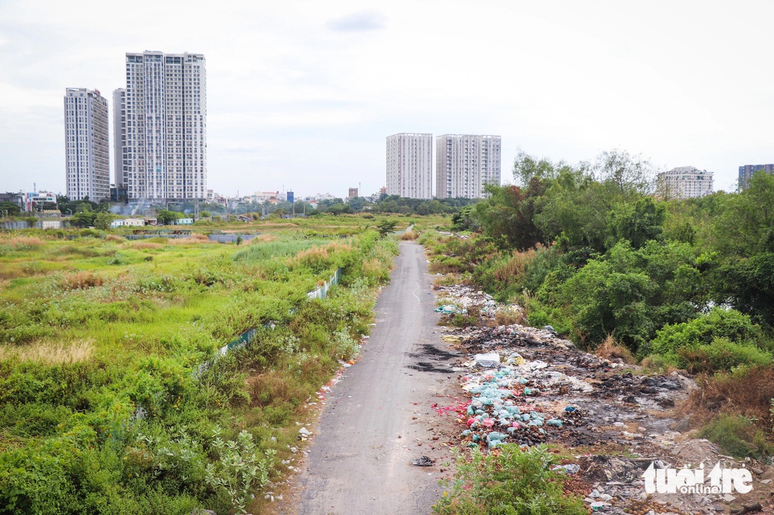 Còn khu tái định cư Thủ Thiêm (trong khu đô thị Nam Rạch Chiếc, thuộc TP Thủ Đức) chỉ có khoảng 30 hộ dân sinh sống. Đường song hành với cao tốc TP.HCM - Long Thành - Dầu Giây là lối dẫn vào khu này đã được khánh thành, khang trang. Nhưng đường sá trong khu tái định cư Thủ Thiêm chỉ được làm “nửa vời”, rác rến bủa vây - Ảnh: ĐỨC PHÚ