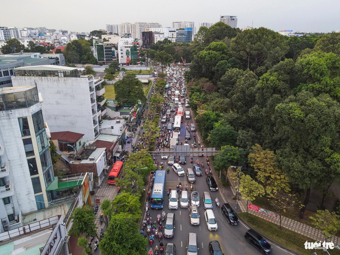 Phía xa, hàng rào chắn công trình làm dự án hầm chui, dự án đường nối đường Trần Quốc Hoàn - Cộng Hòa vẫn đang án ngữ chiếm một phần mặt đường - Ảnh: CHÂU TUẤN