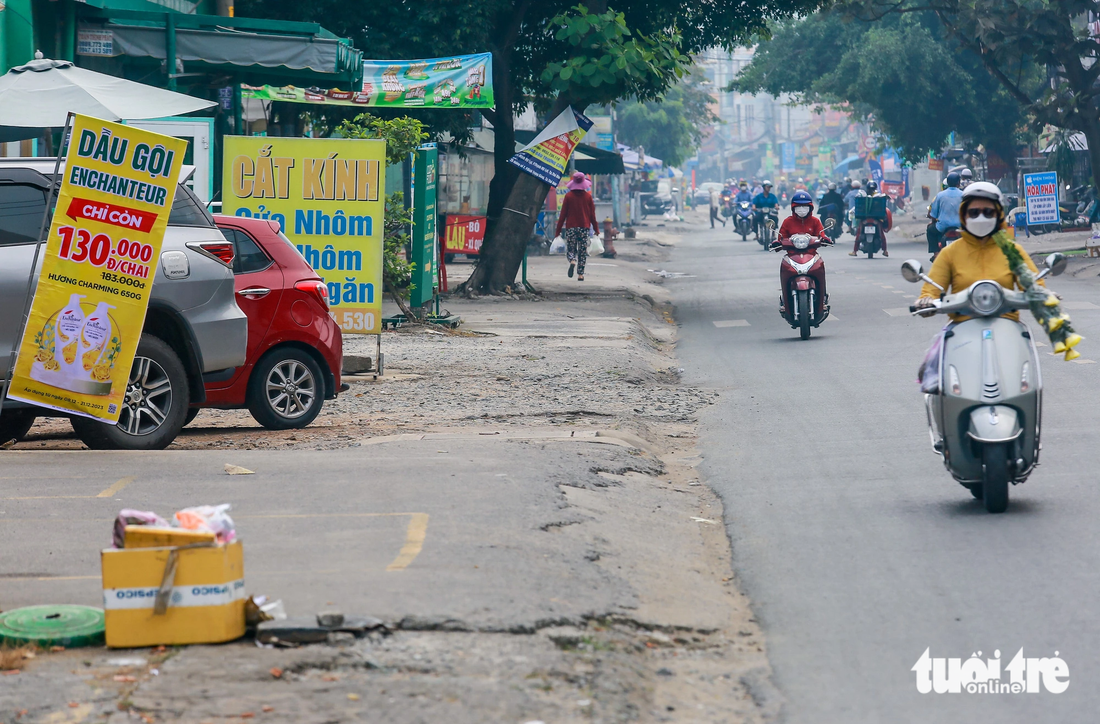 Hầu hết mặt cắt ngang đường Nguyễn Thị Định chỉ rộng từ 6-8m, uốn quanh theo các khu dân cư từ nút giao An Phú về cầu Mỹ Thủy (TP Thủ Đức). Hiện nay nhiều đoạn vỉa hè của đường Nguyễn Thị Định cũng đã hư hỏng trầm trọng. Đá dăm cộng với cát vương vãi gây mất an toàn giao thông, đặc biệt đối với người đi xe máy - Ảnh: LÊ PHAN