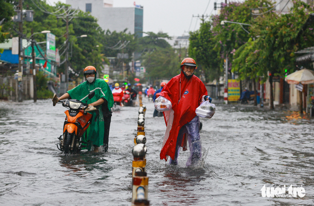 Mưa lớn giữa trưa ở TP.HCM, nhiều đường thành sông - Ảnh 1.