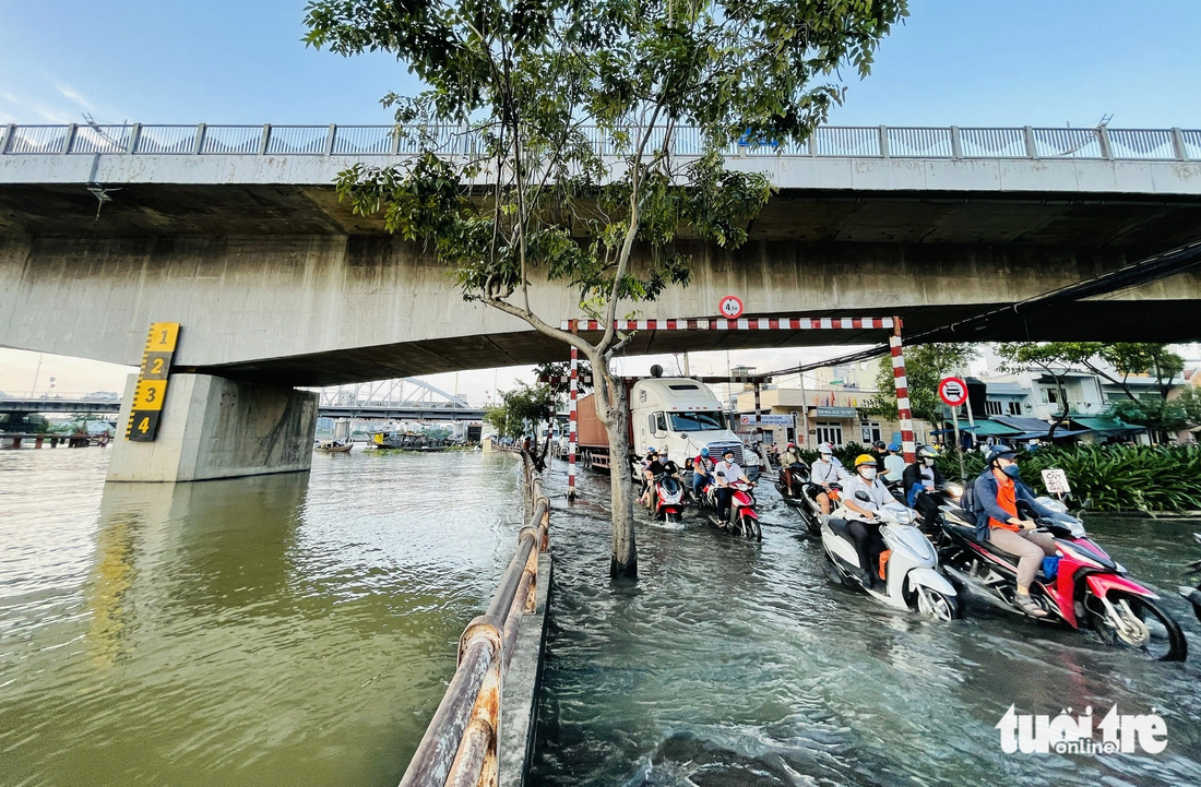 Nằm ngay cạnh cống ngăn triều Tân Thuận, đường Trần Xuân Soạn, quận 7 vẫn ngập nặng vào mỗi đợt triều cường. Thời điểm đỉnh triều, nước kênh Tẻ tràn lên khiến đường và kênh hòa làm một - Ảnh: LÊ PHAN