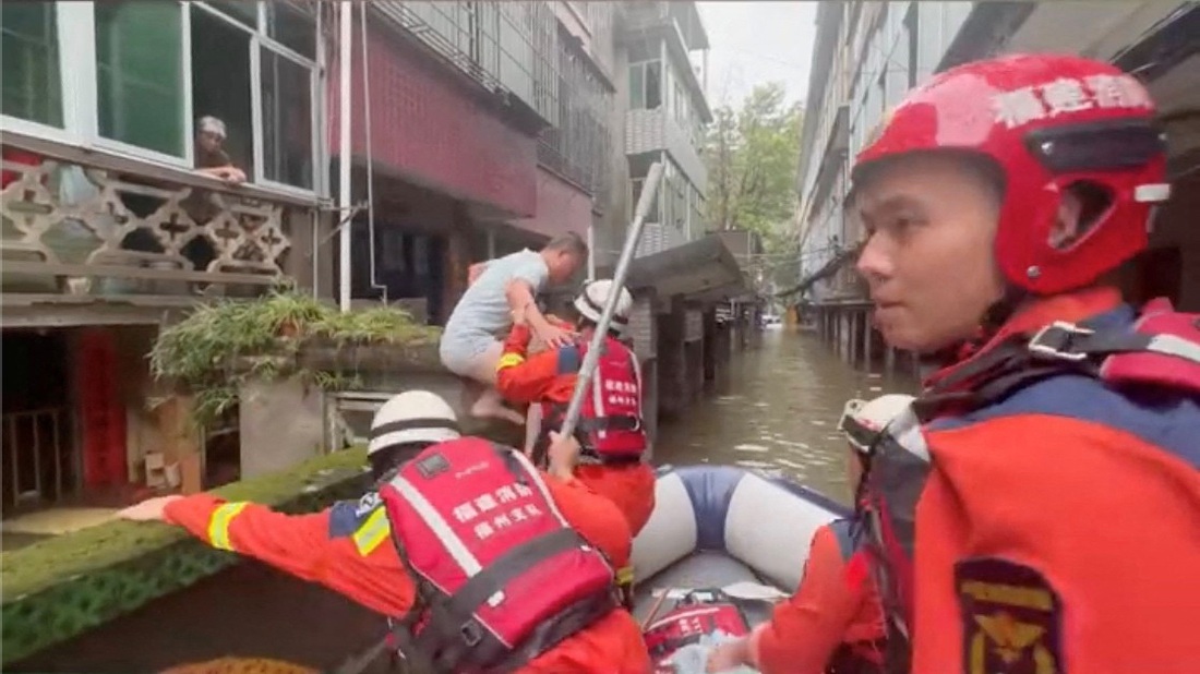 Lực lượng cứu hộ hỗ trợ người dân - Ảnh: REUTERS