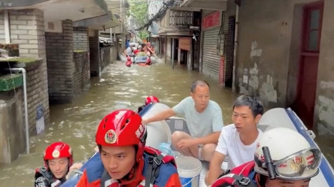 Người dân được đưa ra khỏi vùng ngập nước - Ảnh: REUTERS