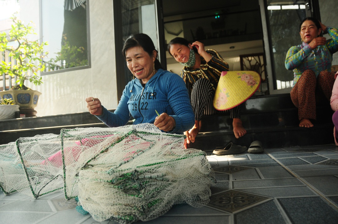 Chồng đi biển, phụ nữ thôn Đông An ngồi lại cùng nhau đan lưới, trò chuyện đợi chồng về - Ảnh: B.D.