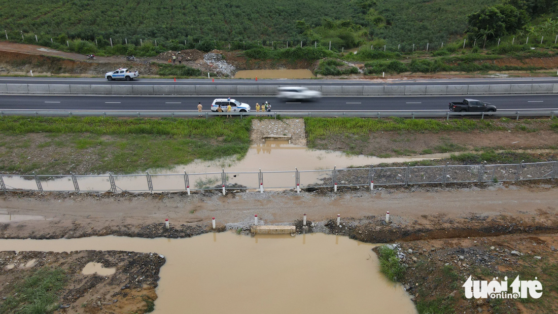 Nước đã dâng lên cao hơn miệng cống ngang cao tốc Phan Thiết - Dầu Giây vào sáng 30-7 - Ảnh: ĐỨC TRONG