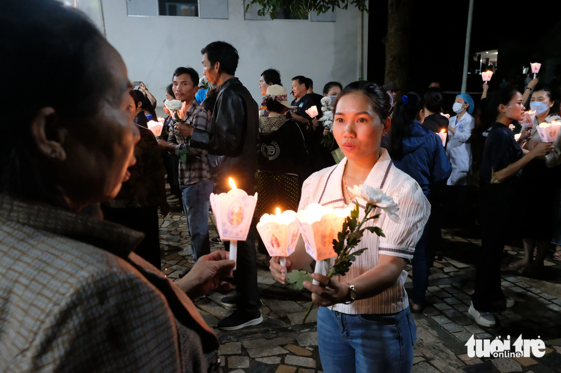 Mỗi người tham gia lễ tưởng niệm cầm một ngọn nến và một đóa hoa  