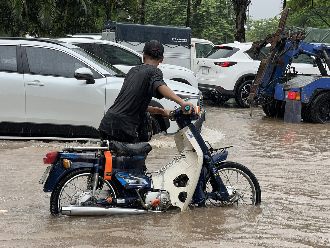 Một người dân đi xe máy bị chết máy trên đường Võ Chí Công - Ảnh: PHẠM TUẤN