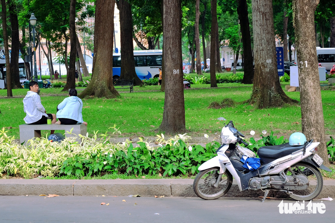 Người đàn ông ngồi hóng mát trong công viên 30 Tháng 4 (quận 1) vẫn không quên quan sát xe mình đậu dưới lòng đường