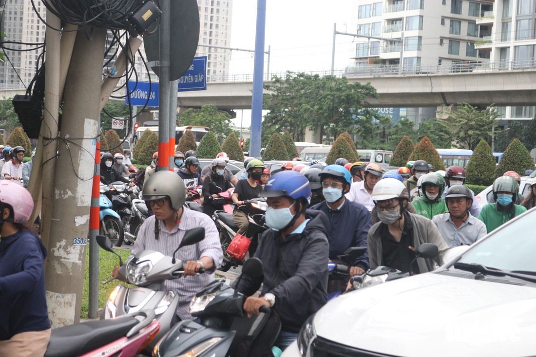 Trên đường Võ Nguyên Giáp với đường 24 (TP Thủ Đức), xe máy và ôtô chen chút nhau, nhích từng chút - Ảnh: TIẾN QUỐC