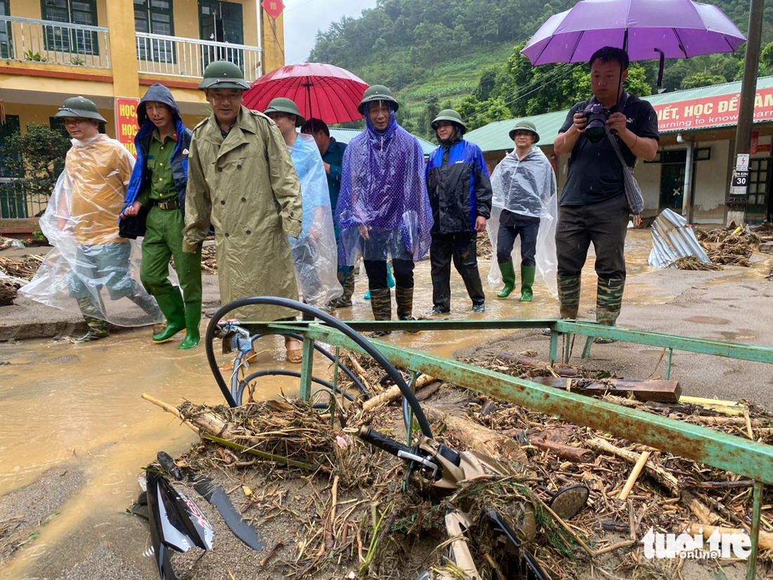 Ông Lê Trọng Khang - chủ tịch UBND huyện Mù Cang Chải (đi đầu, áo xanh) - trực tiếp chỉ đạo lực lượng chức năng, vận động bà con huy động máy móc, con người để xử lý bùn đất sau lũ quét tại Trường tiểu học và THCS Hồ Bốn, đồng thời rà soát trang thiết bị để đề xuất phương án xử lý - Ảnh: CHÍ TUỆ