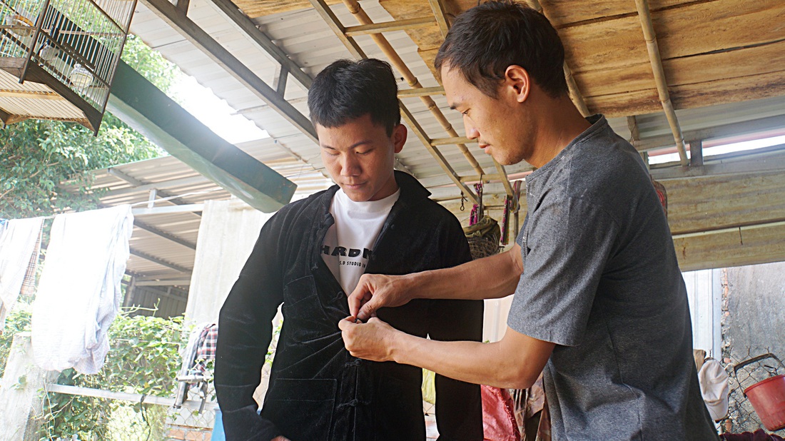 Ông Lý Văn Nhà, trưởng bản Giang Châu, tặng Sùng A Giàng chiếc áo truyền thống của người dân tộc Mông chúc mừng em đậu đại học