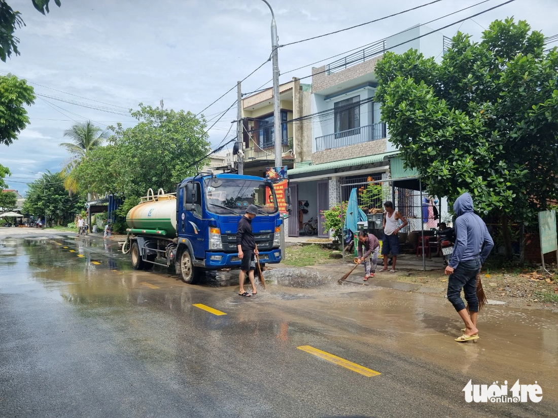 Chính quyền và người dân huy động xe bồn xịt rửa đường do bùn đất lấp 