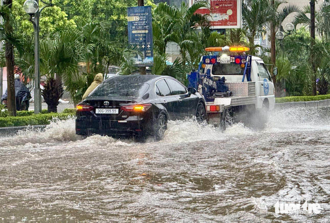 Một chiếc ô tô bị chết máy đang được xe cứu hộ cẩu đi - Ảnh: NGUYỄN KHÁNH