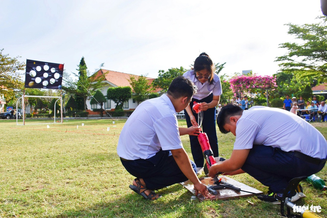 Một đội thi chuẩn bị cho phần thi bắn tên lửa nước bung dù - Ảnh: TRẦN HOÀI