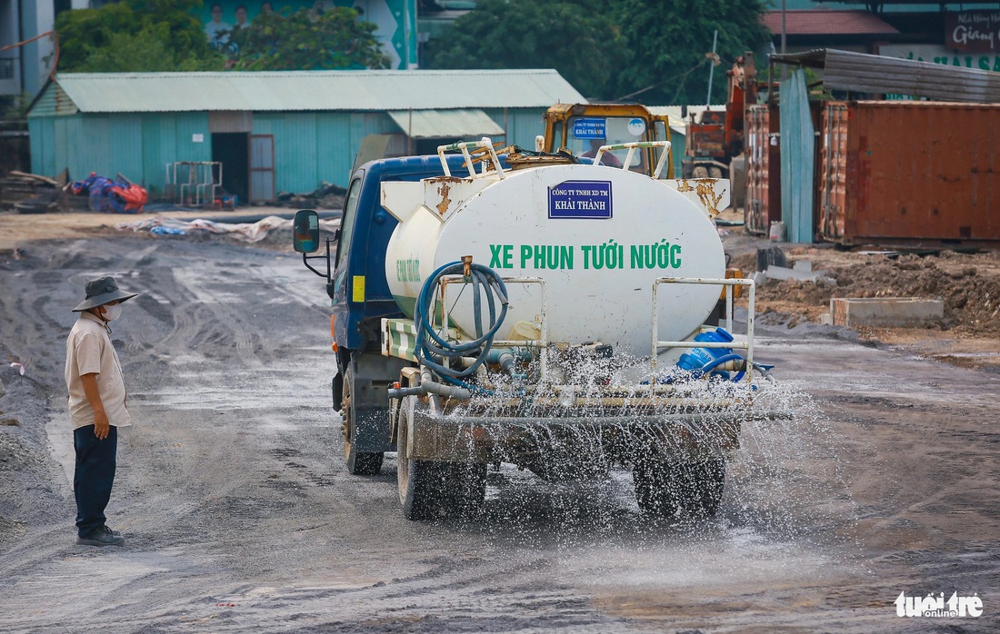 Để hạn chế bụi bặm, đơn vị thi công thường xuyên cho xe xịt nước trong công trường. Các công nhân cũng tất bật san phẳng mặt đường, lắp hệ thống thoát nước…