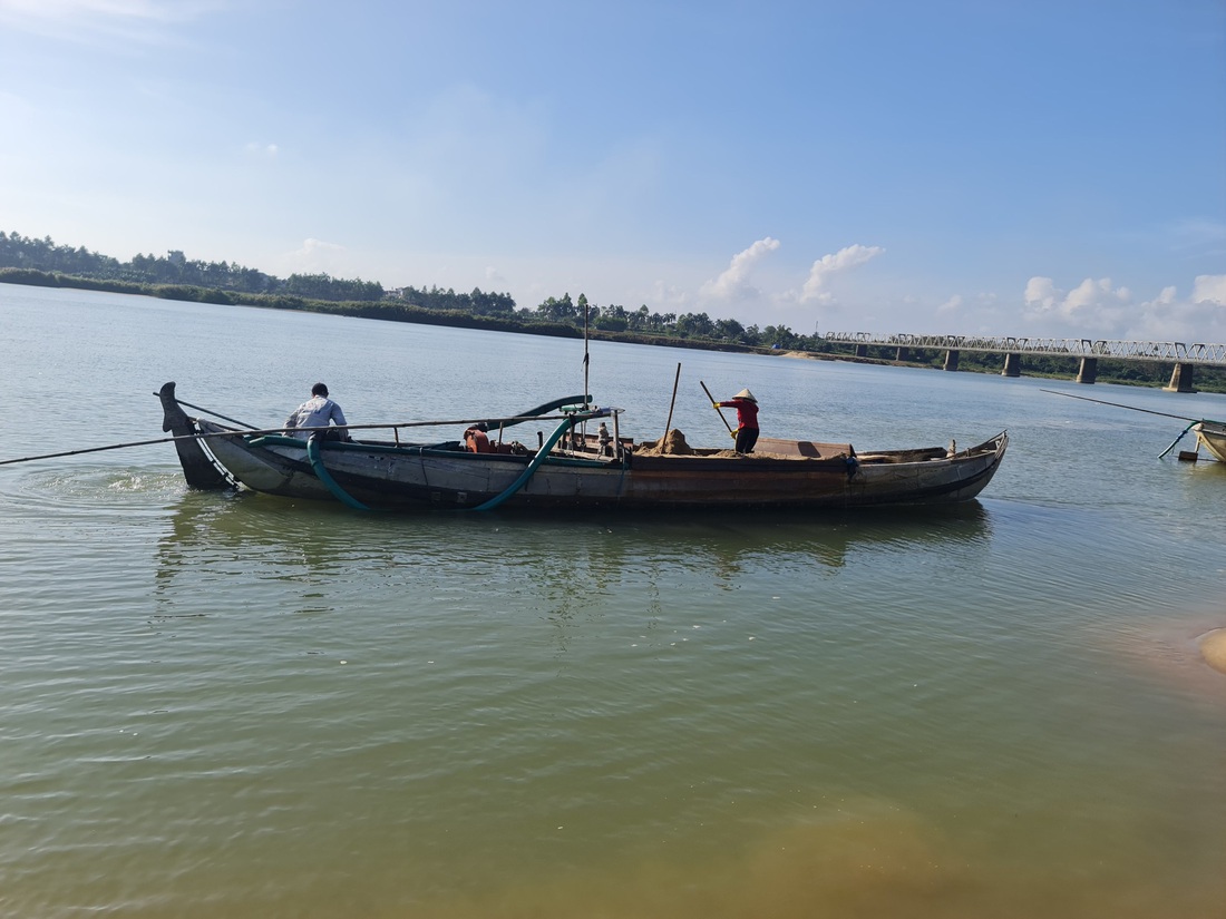 Thời điểm bí thư huyện ủy đi kiểm tra, một ghe hút cát trái phép vội vã rời khỏi bến - Ảnh: TRẦN MAI