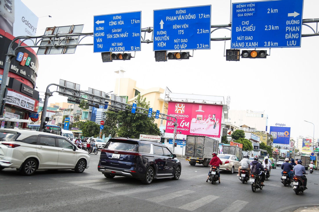 Xe nối đuôi nhau ráng vài giây vượt đèn vàng ở ngã tư Phú Nhuận trưa 23-1 - Ảnh: PHƯƠNG QUYÊN 