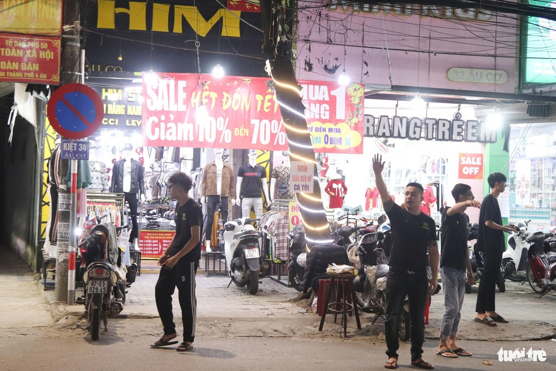 Toàn bộ nhân viên của cửa hàng HIM (34 Âu Cơ, quận Liên Chiểu, Đà Nẵng) tràn ra đường mời gọi khách hàng - Ảnh: THANH NGUYÊN