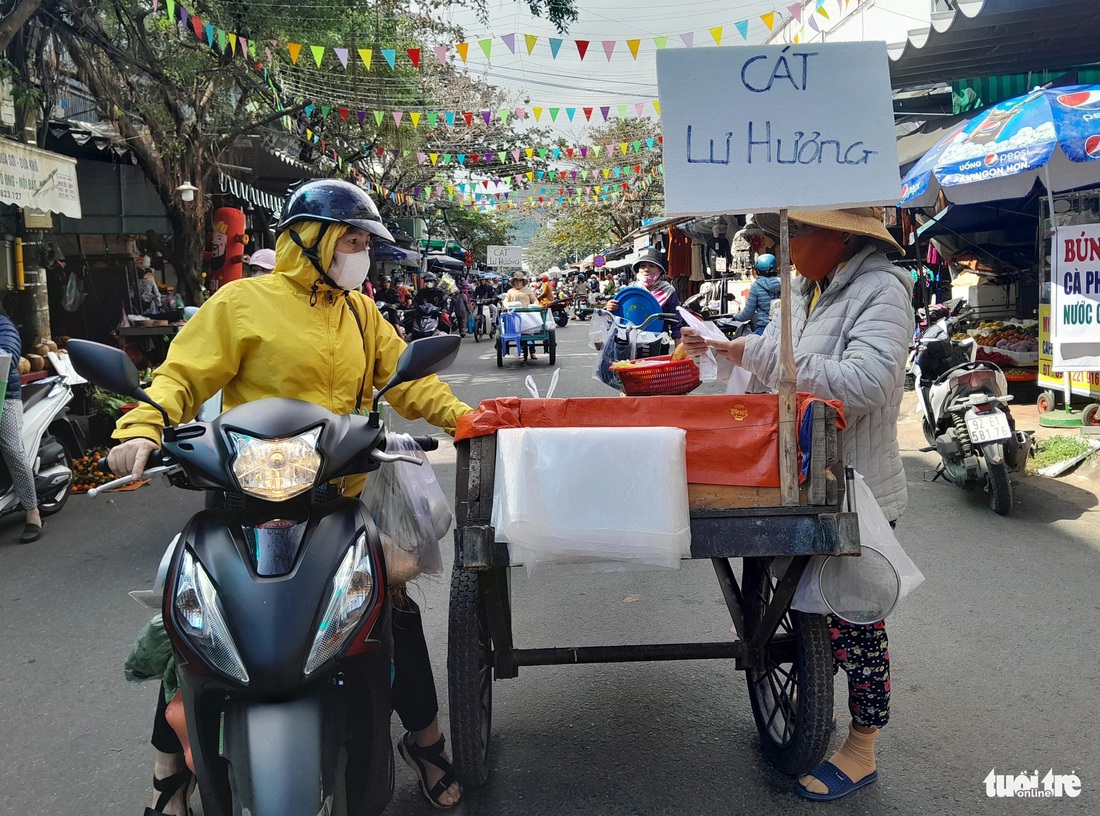 Người dân dừng xe mua cát trắng về thay cho lư hương - Ảnh: MINH NGUYỆT