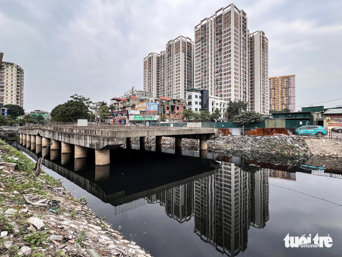 Cây cầu bắc qua sông Lừ xây dựng dang dở vẫn trơ khung sắt, rêu phủ dày đặc - Ảnh: HỒNG QUANG