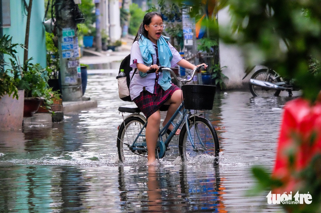 Hẻm ở quận Bình Tân lại ngập tới đầu gối, học sinh lội nước thối tan trường - Ảnh 1.